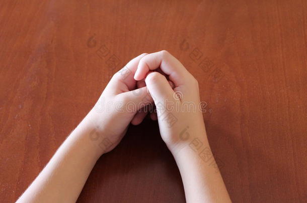 手放在桌子上，两只手臂，身体部分，木制家具，孩子们的手，