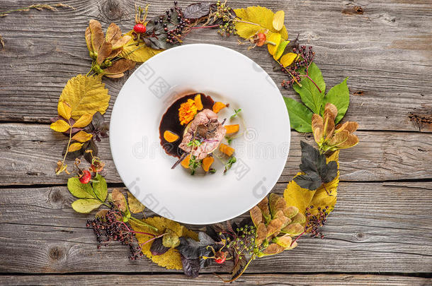 独家秋季食品在白色盘子装饰花，草药，酱汁和叶子，产品摄影餐厅，牛肉或