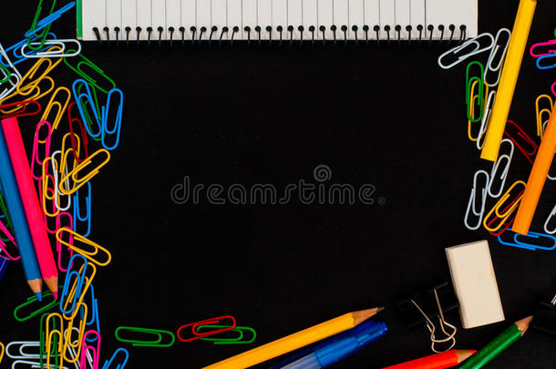 彩色学校或办公室风格的背景与剪辑，铅笔，橡皮擦和内衬的记事本在深色木桌背景