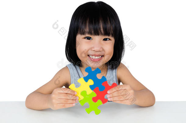 亚洲小中国女孩玩五颜六色的拼图