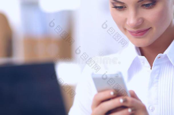 女商人在办公室里用智能手机发送信息