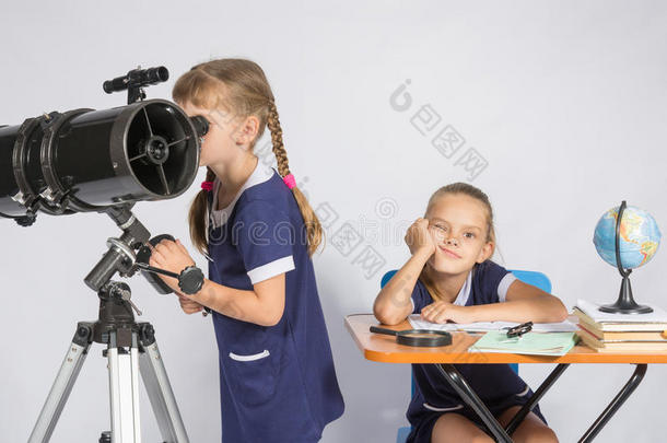 一个女孩透过望远镜看，另一个女孩在等待悲伤的结果