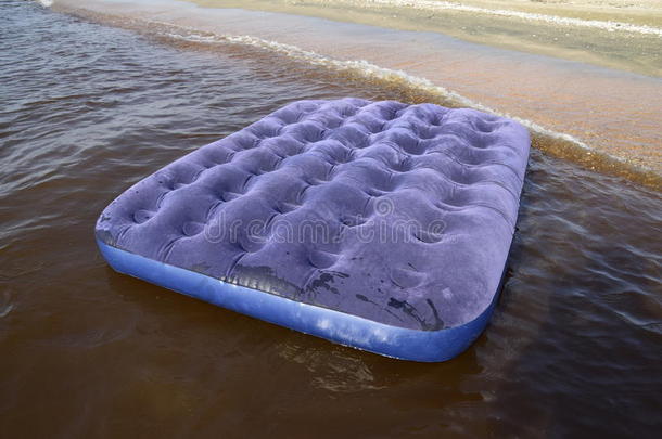蓝色充气床垫在池塘里游泳