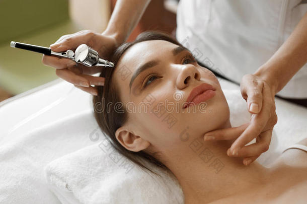 面部美容治疗。 女人被氧气皮肤剥落