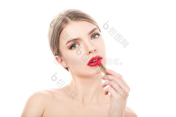 美丽的年轻女人用口红涂嘴唇。 完美的化妆。 美容时尚