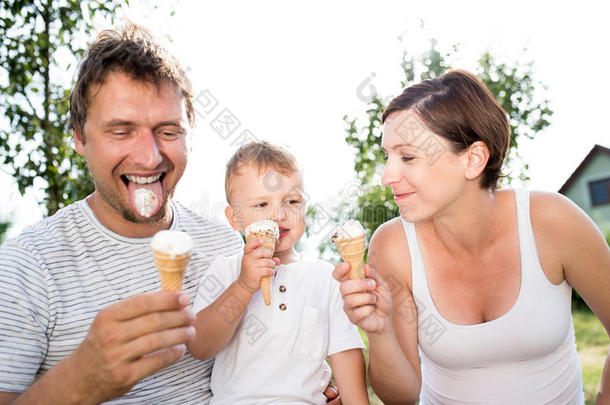 爸爸，妈妈和儿子吃冰淇淋，阳光明媚的夏天