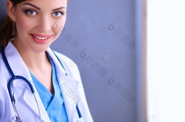 医生女人用听诊器在灰色背景上