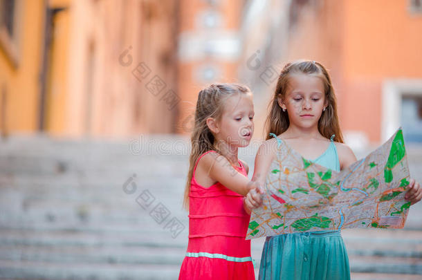 可爱的小女孩看着意大利罗马街道上的旅游地图。 快乐的托德勒孩子们喜欢意大利假期