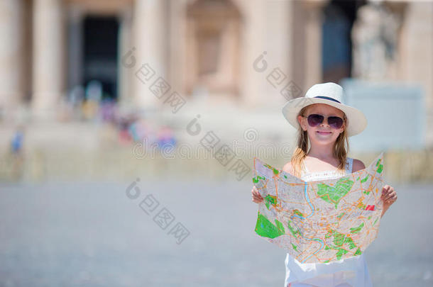 可爱的小女孩与<strong>旅游地</strong>图在圣彼得大教堂广场，意大利。快乐的图德勒孩子享受意大利假期
