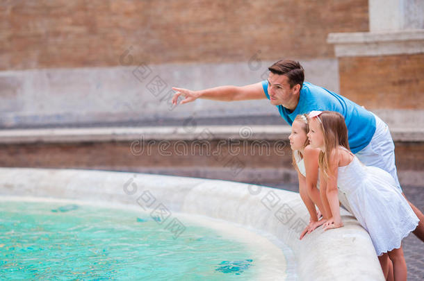 罗马特雷维喷泉附近的家庭。 快乐的孩子和爸爸在意大利享受他们的欧洲假期