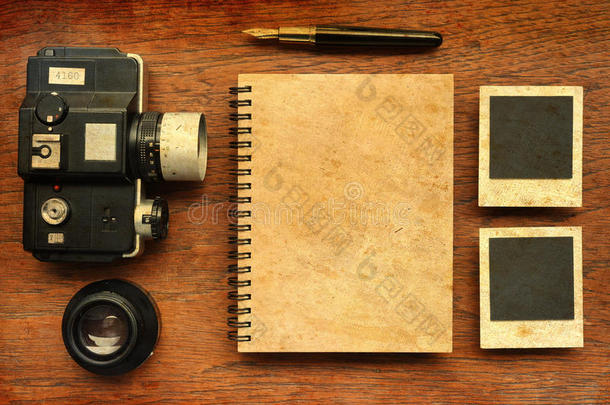 木制背景上有钢笔、相框和照相机的空白笔记本