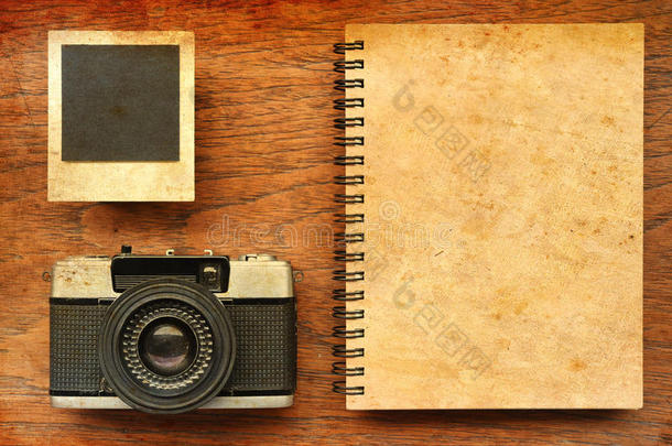 木制背景上有相框和照相机的空白笔记本