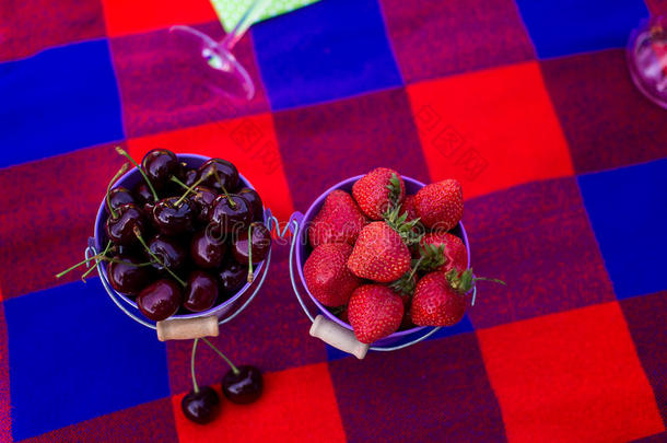 桶里有樱桃和草莓。 在单身派对上野餐