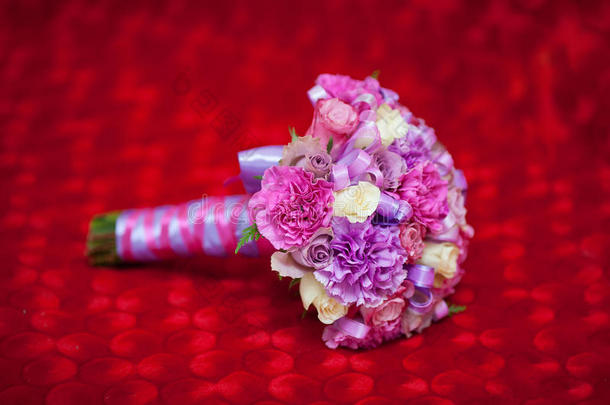 红色背景下美丽的粉红色婚礼花束特写镜头