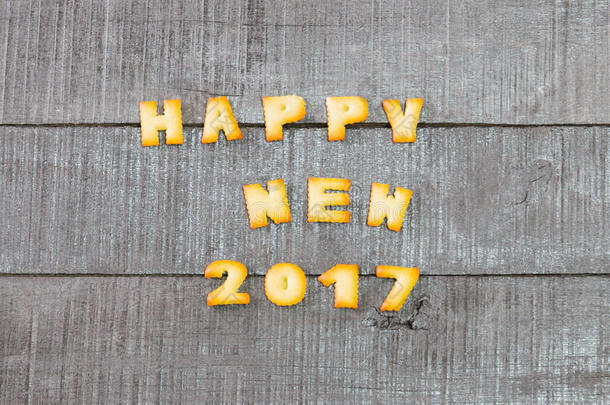 饼干在旧木地板上粘贴文字快乐的新年。