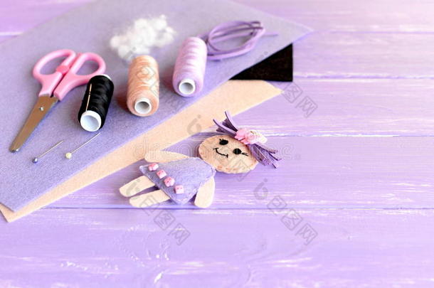 有趣的娃娃装饰按钮，线套，针，别针，剪刀，平片毡在木制背景与空白的地方