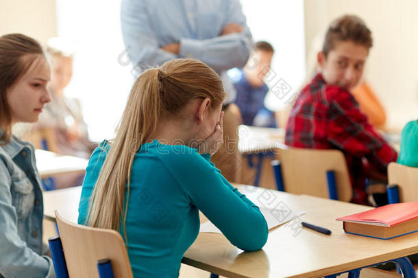 哭泣的学生女孩与测试结果和老师