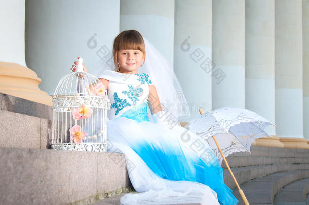 小新娘。一个穿着华丽的白色和蓝色婚纱的女孩