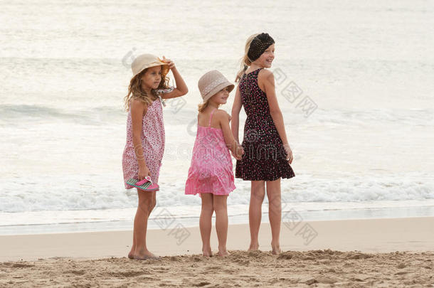 三个姐妹站在海滨，回头看着一个人在嘘
