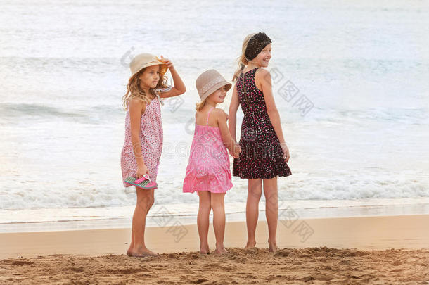三个姐妹站在海滨，回头看着一个人在嘘