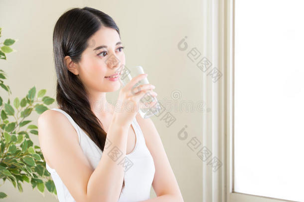美女喝着干净的水，看着窗外