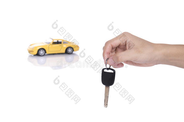 手拿汽车钥匙和黄色微型汽车