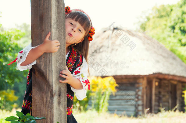 女孩<strong>戴</strong>着花环和一套西装，在乡下用木屋装饰乌克兰的装<strong>饰品</strong>