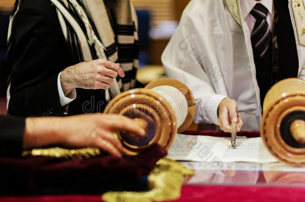 男孩在成人礼上阅读犹太律法的手