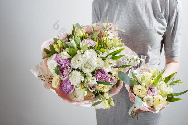 花店女孩带着丰富的束花。 新鲜的春天花束。 暑期背景。 年轻女子生日或母亲花