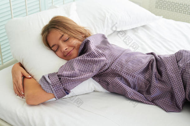 穿着睡衣睡觉拥抱枕头的漂亮年轻女人