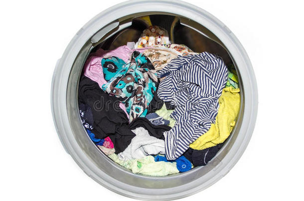 一台现代洗衣机的特写，里面装着白色背景上隔离的衣服。 洗衣机里满是脏衣服，CL