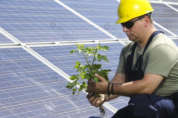 绿色能源，工人正在太阳能电池板附近的工厂