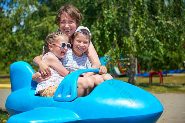 孩子和女人在城市公园乘坐<strong>蓝色</strong>飞机，快乐的家庭，暑假的概念