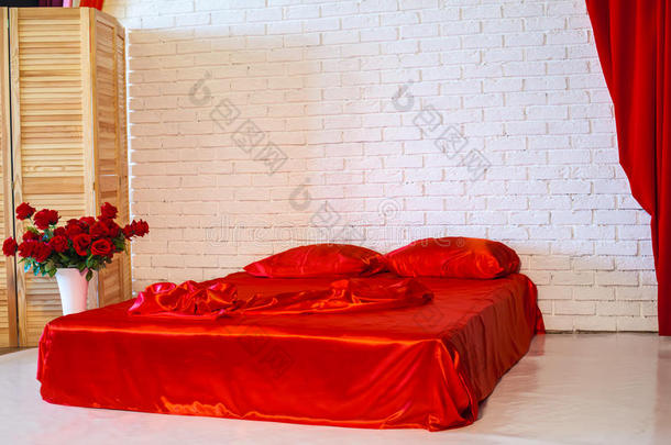 白色房间里有红色床单的床