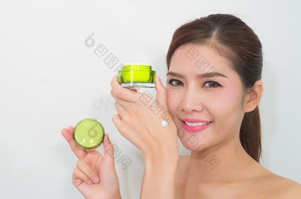 美丽的亚洲女人使用天然护肤品，保湿