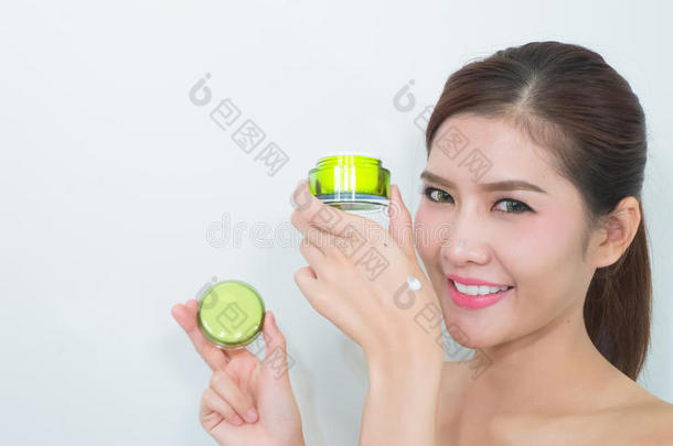 美丽的亚洲女人使用天然护肤品，保湿