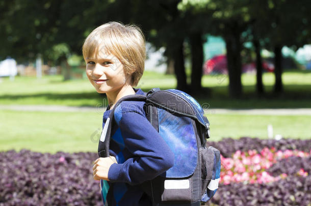 带着背包的孩子去上学。 城市公园背景