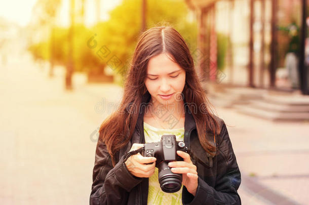 兴高采烈的年轻女子在数码单反相机上看镜头