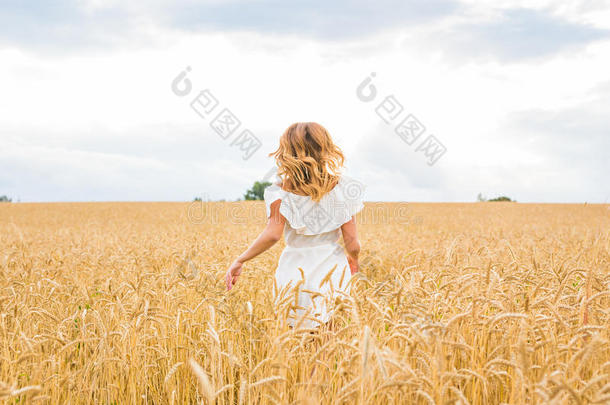 美丽的女孩在田野上奔跑。 自由概念背景。
