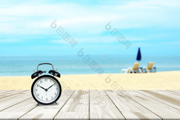 木桌上的闹钟和海滩背景模糊