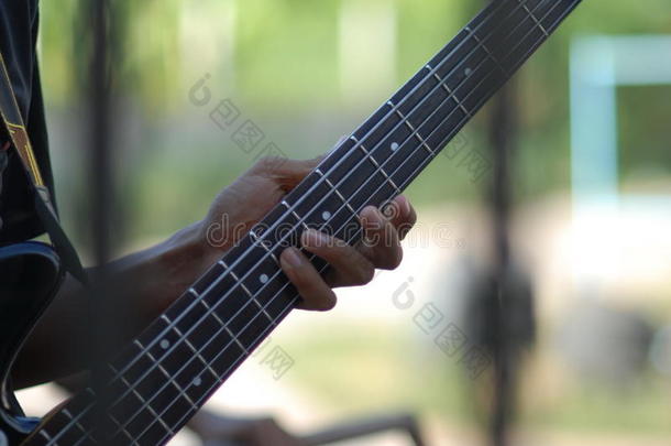 音乐人的手指手在泰国弹电吉他低音