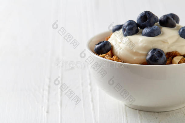 一碗全谷物莫斯利，蓝莓和酸奶在白色