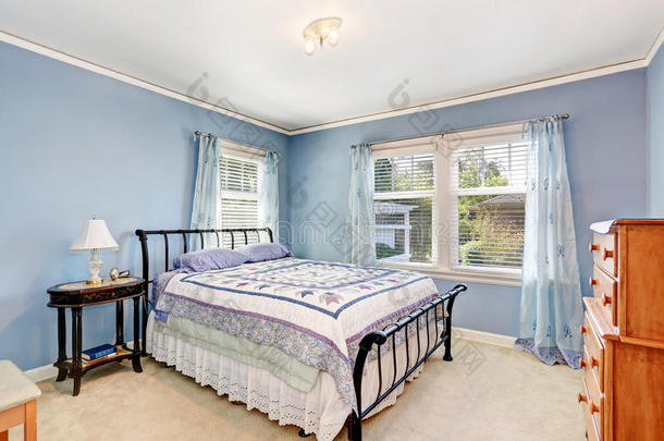 卧室内部有五颜六色的床上用品和地毯地板。