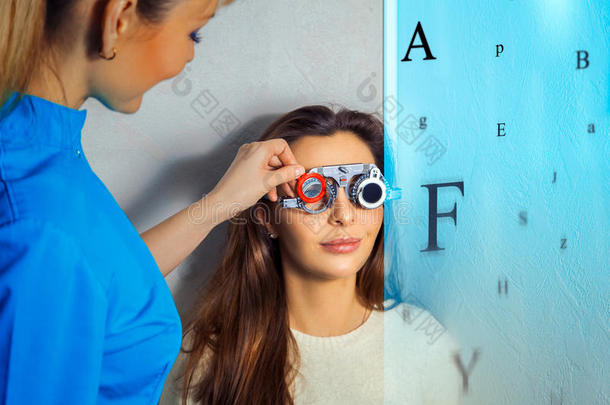 成年妇女在眼科医生检查视力并进行纠正