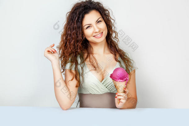 开心的小女孩拿着粉红色的冰淇淋筒在镜头前微笑
