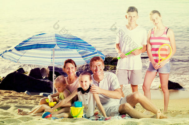 活跃的家庭和孩子一<strong>起坐</strong>在海滩上