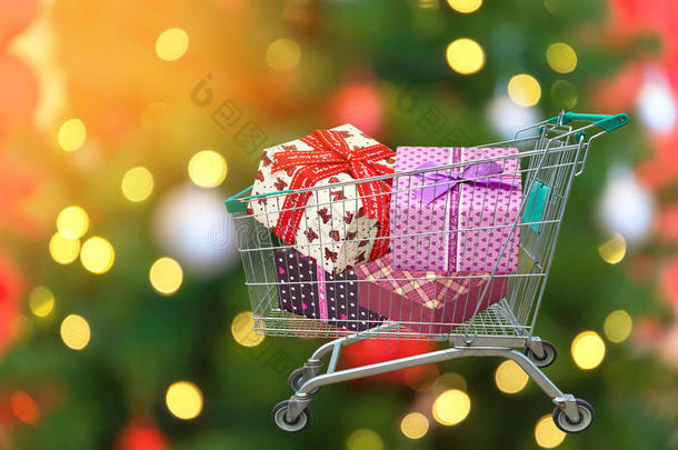 圣诞礼物和礼物在购物车与模糊的灯光背景。