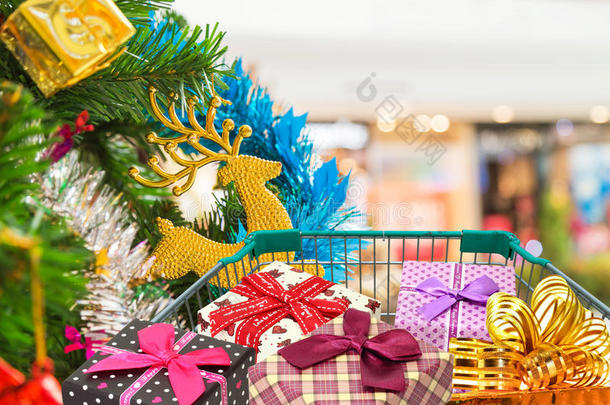 圣诞礼物和礼物在购物车与圣诞树背景。