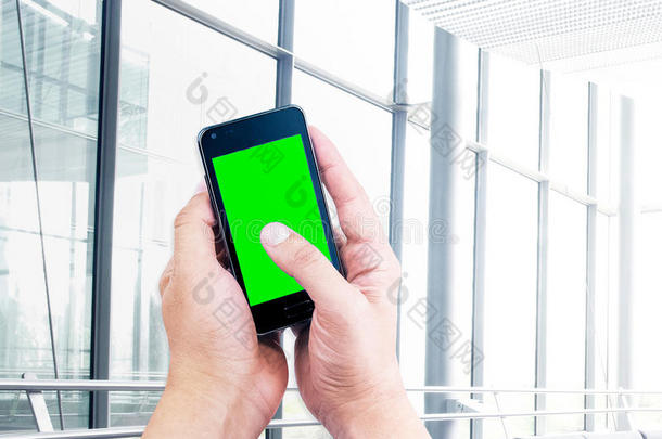商务人士使用手机智能手机与色度键绿色屏幕在街道户外背景