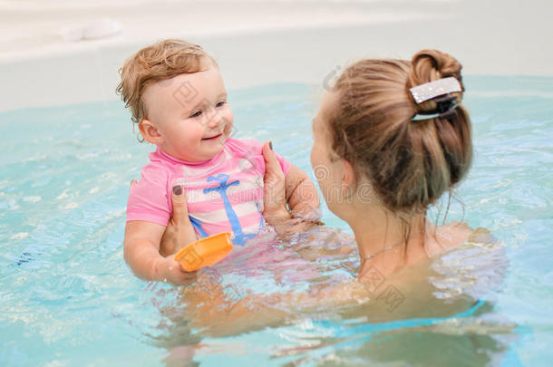 白色白种人母亲和<strong>婴儿</strong>女儿在<strong>游泳池</strong>里玩水的集体肖像